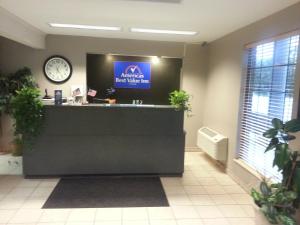um lobby com um balcão com um relógio na parede em Americas Best Value Inn & Suites - Bluffton em Bluffton