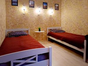 1 dormitorio con 2 camas, mesa y 2 lámparas en Sofija apartamenti, en Daugavpils