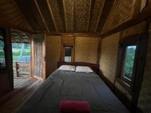 a large bed in a room with windows at Padi Bungalows in Tetebatu