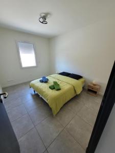 1 dormitorio con 1 cama con manta amarilla en Landes, maison de vacance jumelée à linxe, en Linxe