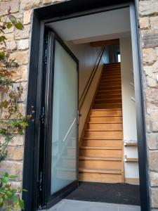 a glass door leading up to a staircase at Juste à Côté - duplex tout confort in Esneux