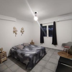 a bedroom with a bed in a white room at La villa de la Rivière du mât in Saint-André