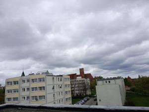 a group of buildings in a city under a cloudy sky at Apartament koło Zamku in Malbork