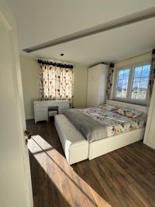1 dormitorio con 1 cama grande y 2 ventanas en Villa Morina, en Tropojë
