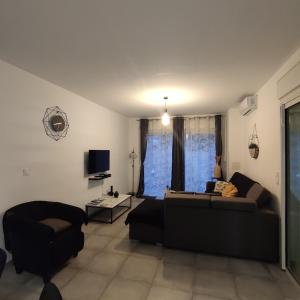 a living room with a couch and a tv at La villa de la Rivière du mât in Saint-André +12 photos