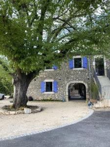 un bâtiment avec un arbre en face dans l'établissement Chambre d'hôtes Lavande, à Lagorce