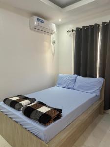 a bedroom with a bed with a air conditioner on it at Casa Amores: Camaya Coast in Mariveles