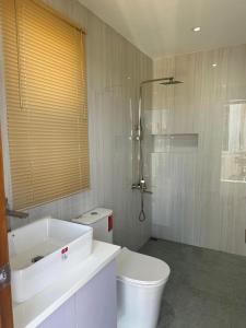 a white bathroom with a toilet and a shower at Casa Amores: Camaya Coast in Mariveles