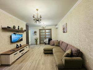 a living room with a couch and a tv at Tbilisi-apartment in Tbilisi City