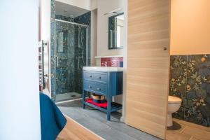La salle de bains est pourvue d'un lavabo bleu et d'une douche. dans l'établissement Les Jardins de l'Orangerie, à Durtal