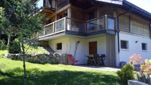 a house with a balcony and a table in a yard at studio des dents de lanfon in Écharvine