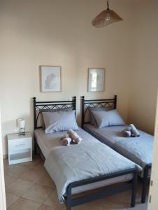 a bedroom with two beds with stuffed animals on them at LEONIDAS in Káto Vasilikí