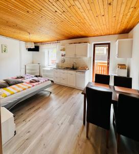 a room with a bed and a table and a kitchen at Apartma Lip in Rateče