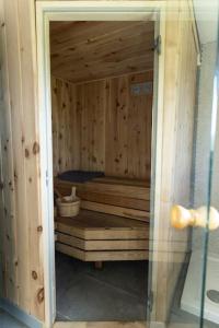 una sauna in legno con porta in vetro in camera di Avantura Avala a Belgrado