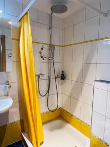 La salle de bains est pourvue d'une douche avec rideau de douche jaune. dans l'établissement Wonderful & Private Room with en-suite bathroom, à Triesenberg