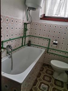 a bathroom with a bath tub and a toilet at Aki in Drvar