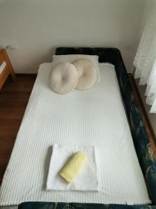a white bed with two pillows and a sponge on it at Aki in Drvar