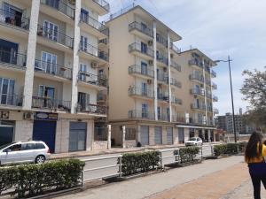 a woman walking down a sidewalk in front of a tall building at due stanzulelle sul mare B&B in Salerno