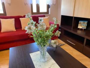 a vase of flowers on a table in a living room at Guest House Persa in Gjirokastër