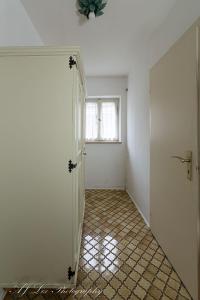 une chambre vide avec une porte et une fenêtre dans l'établissement Pension Karner, à Mittenwald