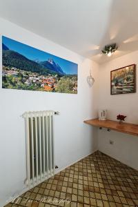 une chambre avec un radiateur et une photo sur la paroi dans l'établissement Pension Karner, à Mittenwald