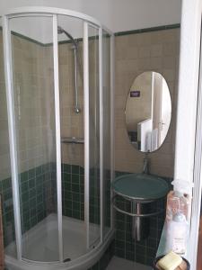 La salle de bains est pourvue d'une douche, d'un lavabo et d'un miroir. dans l'établissement Appartement spacieux et confortable, à Valence