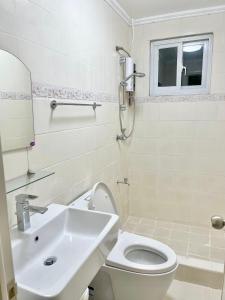 a bathroom with a white toilet and a sink at Explore Iloilo - Accessible Apartment in Iloilo City