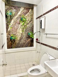 a bathroom with a toilet and a window with plants at Explore Iloilo - Accessible Apartment in Iloilo City