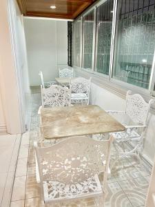 a table and chairs in a room with windows at Explore Iloilo - Accessible Apartment in Iloilo City