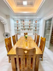 a dining room with a wooden table and chairs at Explore Iloilo - Accessible Apartment in Iloilo City
