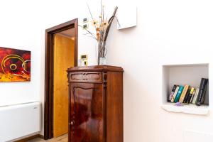 eine Vase auf einem Holzschrank in einem Raum in der Unterkunft S. Martin Hotel in Giovinazzo