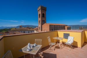 d'un balcon avec une table, des chaises et une tour d'horloge. dans l'établissement Casa Matilde panoramic apartment, à Montecarlo