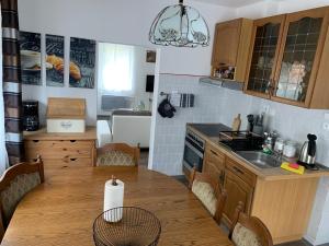 a kitchen with a wooden table with chairs and a sink at hřensko 114 in Hřensko