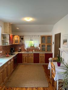a large kitchen with wooden cabinets and a table at Dom Natura in Grzybowo