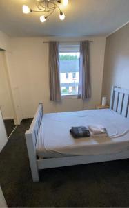 een slaapkamer met een wit bed en een raam bij Modern Quiet City Center Airport 2 Bedroom Apartment in Edinburgh