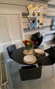 a dining room with a table and chairs with a vase of flowers at Modern Quiet City Center Airport 2 Bedroom Apartment in Edinburgh