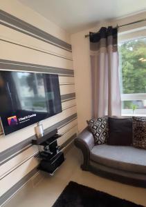 a living room with a couch and a flat screen tv at Modern Quiet City Center Airport 2 Bedroom Apartment in Edinburgh