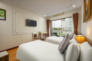 a hotel room with two beds and a television at Tunger Premium Hotel & Travel in Hanoi
