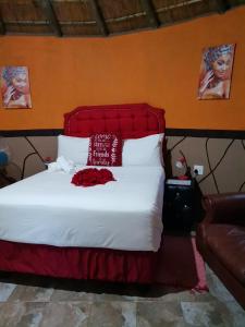 a bedroom with a large bed with a red headboard at Lungakaunakho Country Lodge in Port Edward
