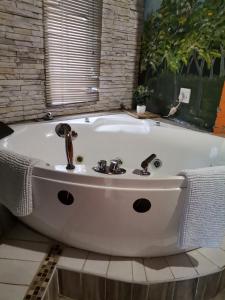 a white bath tub in a bathroom with a window at Lungakaunakho Country Lodge in Port Edward