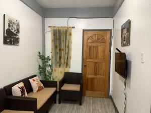 a living room with a couch and a door at Romblon Transient House 2nd Floor in Romblon
