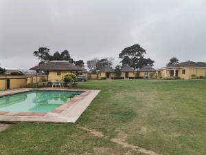 un patio con piscina y casas en Lungakaunakho Country Lodge, en Port Edward