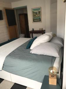 uma cama com quatro almofadas em cima em La Loge de Marguerite em Champtoceaux