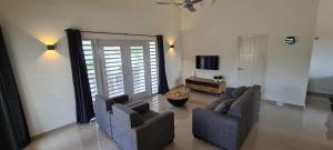 - un salon avec deux chaises et une télévision dans l'établissement Bonaire Village Villa 23, à Kralendijk