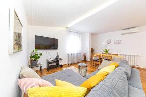 ein Wohnzimmer mit einem grauen Sofa und gelben Kissen in der Unterkunft Apartments Iskra in Split