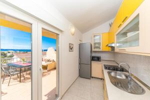 eine Küche mit Blick auf eine Terrasse mit einem Tisch in der Unterkunft Apartments Iskra in Split