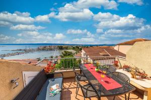 einen Balkon mit einem Tisch und Stühlen sowie Blick auf das Wasser in der Unterkunft Apartments Iskra in Split