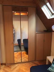 a large wooden cabinet with glass doors in a room at Szalonka apartman in Budakalász