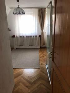 a room with a window and a rug and a door at Szalonka apartman in Budakalász