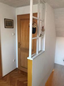 a room with a door and a shelf with a plant at Szalonka apartman in Budakalász